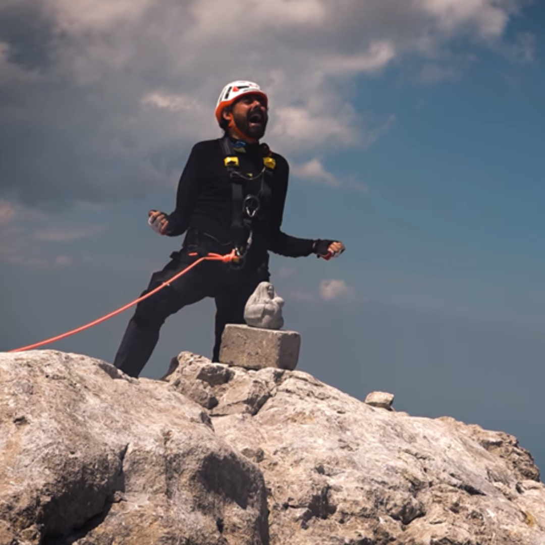 Miguel Ángel Roldán Marín en la cima de una montaña lanzando un grito de superación
