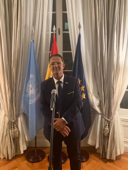 Juan Carrión posando delante de las banderas internacionales.