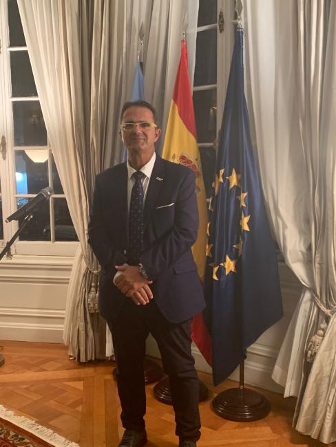 Juan Carrión posando delante de las banderas internacionales.