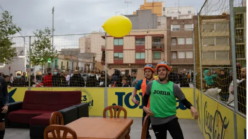 Fotografía: dos personas persiguiendo un globo amarillo