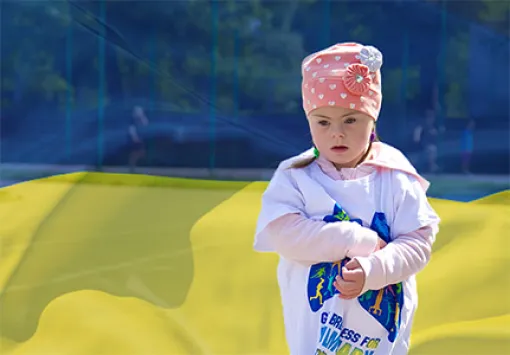 Imagen de una niña frente a la bandera de Ucrania.